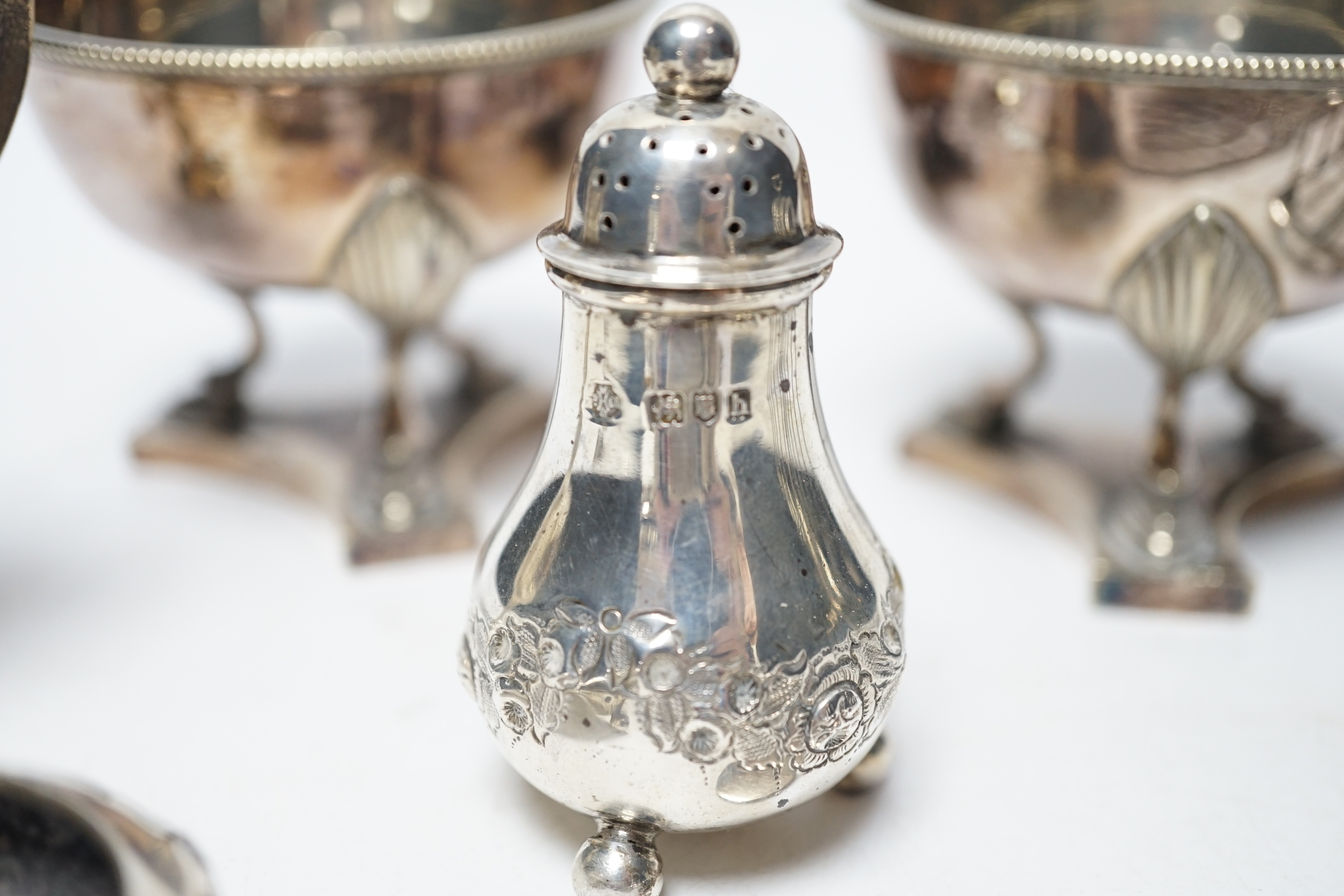 Twelve assorted silver condiments, including a set of four Edwardian bun salts, William Hutton & Sons, London, 1903, a set of six silver handled tea knives, a small silver trophy cup, silver napkin ring, cased silver thi